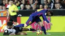 Pemain Barcelona, Lionel Messi berebut bola dengan pemain Valencia, Carlos Soler pada lanjutan La Liga Primera Division di Stadion Mestalla, Minggu (26/11). Valencia memaksa Barcelona meraih hasil imbang 1-1.  (AP/Alberto Saiz)