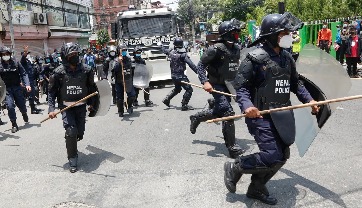 Polisi saat membubarkan massa aksi di Nepal (11/6/2020). Sekitar 1000 pemrotes berkumpul menuntut peningkatan pengujian dan dugaan korupsi oleh pejabat pemerintah saat membeli peralatan dan alat uji. (AP Photo/Niranjan Shrestha)