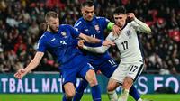 Gelandang Timnas Inggris, Phil Foden, diadang dua pemain Serbia, Strahinja Pavlovic (kiri) dan Filip Kostic (tengah) saat tampil di laga Grup K Kualifikasi Piala Dunia 2026 yang berlangsung di Wembley Stadium, London, Jumat (14/11/2025) dini hari WIB. (Ben STANSALL / AFP)