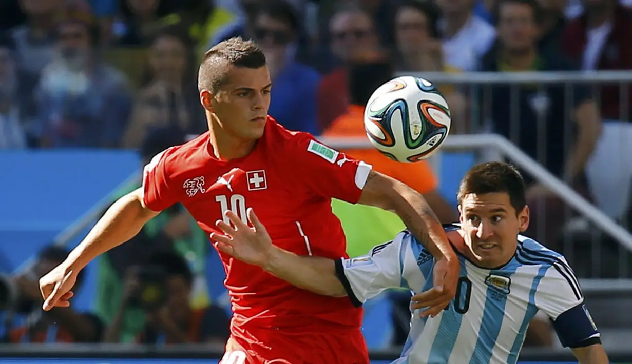 Gelandang Timnas Swiss, Granit Xhaka (kiri) berusaha menahan pergerakan pemain depan Argentina, Lionel Messi, saat berlaga di 16 besar Piala Dunia 2014 di Stadion Corinthians, Sao Paulo, (1/7/2014). (REUTERS/Kai Pfaffenbach)