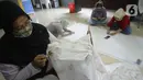Ibu rumah tangga menyelesaikan pembuatan batik kembang mayang di Kampung Batik, Kelurahan Larangan Selatan, Kota Tangerang, Banten, Rabu (26/8/2020). Di tempat yang menjadi destinasi wisata tersebut kita bisa melihat langsung pembuatan dan mengikuti pelatihan membatik. (merdeka.com/Dwi Narwoko)