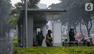 Sejumlah warga berteduh saat hujan di kawasan Bundaran HI, Jakarta, Jumat (18/2/2022). BMKG mengungkapkan potensi curah hujan meningkat dan cuaca ekstrem sepanjang 17-23 Februari 2022. Sejumlah wilayah diminta waspada dampak yang terjadi dari cuaca buruk. (Liputan6.com/Faizal Fanani)