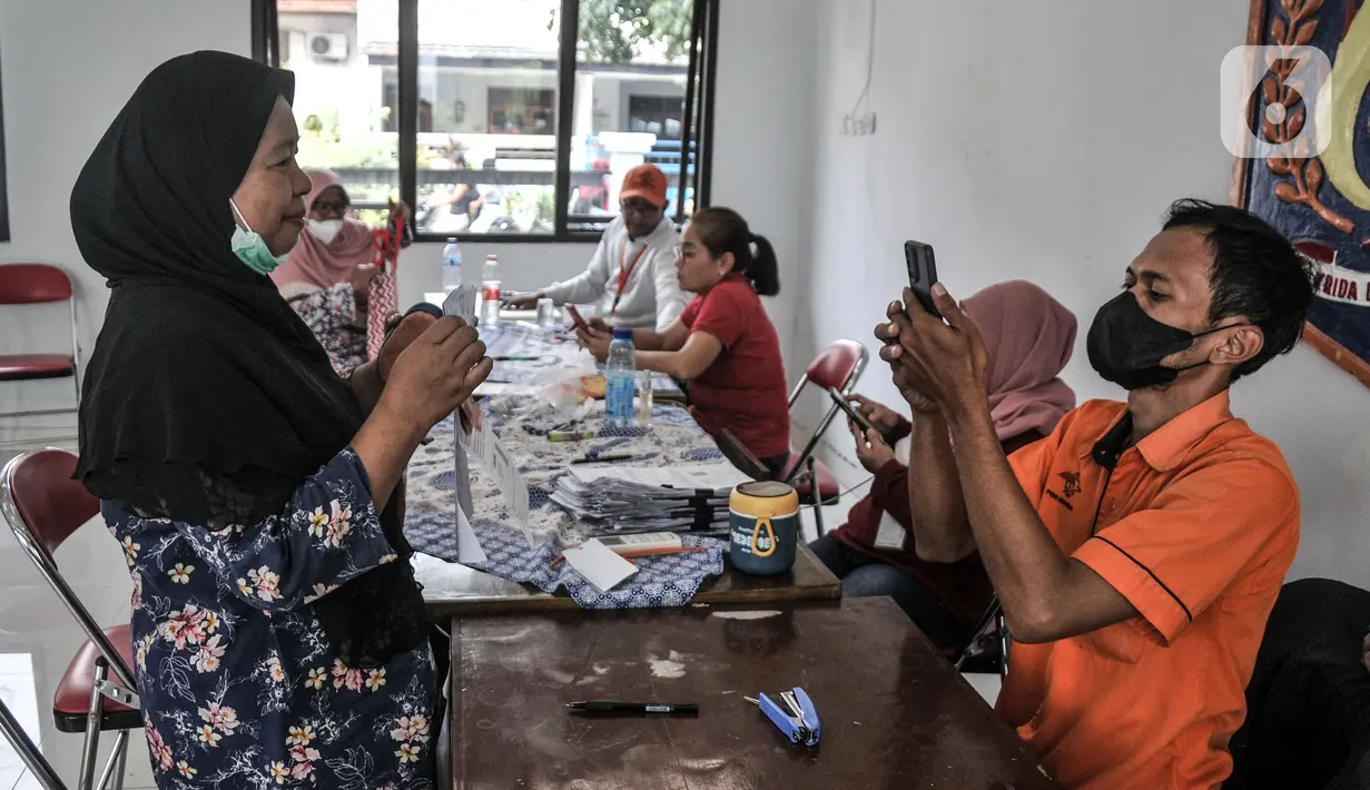 Petugas memotret warga yang menerima Bantuan Langsung Tunai (BLT) Bahan Bakar Minyak (BBM) tahap tiga di Sasana Krida Karang Taruna (SKKT) Kelurahan Pondok Kopi, Kecamatan Duren Sawit, Jakarta Timur, Kamis (22/9/2022). Sebanyak 771 warga di Kecamatan Duren Sawit menerima manfaat BLT tahap tiga sebesar Rp 300 ribu sebagai kompensasi dari naiknya harga BBM. (merdeka.com/Iqbal S. Nugroho)