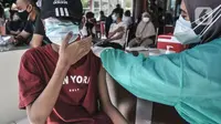 Ekspresi seorang anak saat menerima vaksin Covid-19 dalam program Vaksinasi Keliling di RPTRA Pulo Besar, Sunter Jaya, Jakarta, Selasa (12/7/2021). Kementerian Kesehatan mengalokasi 20 juta dosis vaksin Covid-19 untuk anak usia 12-17 tahun yang diberikan secara bertahap (merdeka.com/Iqbal S Nugroho)