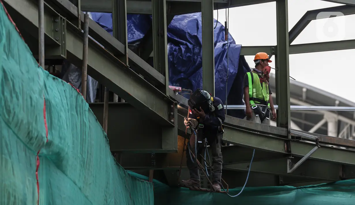 Pekerja menyelesaikan pembangunan halte Centrale Stichting Wederopbouw (CSW) di kawasan Kebayoran Baru, Jakarta, Selasa (8/6/2021). Halte yang akan menghubungkan antar moda transportasi yaitu Transjakarta dengan MRT tersebut mengambil desain Cakra Selaras Wahana. (Liputan6.com/Johan Tallo)