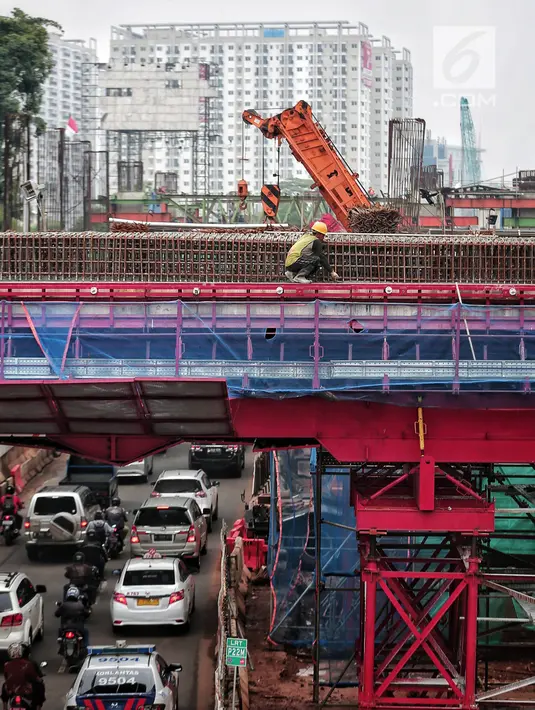 Kendaraan melintas di bawah pembangunan proyek Light Rail Transit (LRT) Jabodebek fase I di kawasan Cawang, Jakarta, Senin (14/1). Progres konstruksi stasiun LRT Cawang, Jakarta Timur sudah mencapai 62,2 persen. (Liputan6.com/Faizal Fanani)
