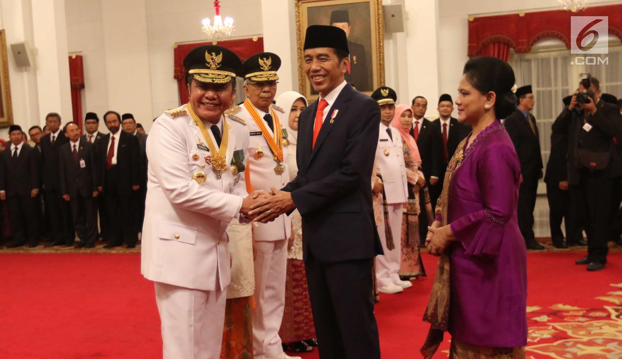 Presiden Joko Widodo atau Jokowi bersalaman dengan Gubernur Sumatera Selatan Herman Deru saat melantik di Istana Negara, Jakarta, Senin (1/10). Herman Deru akan menjalankan masa jabatan periode 2018-2023. (Liputan6.com/Angga Yuniar)