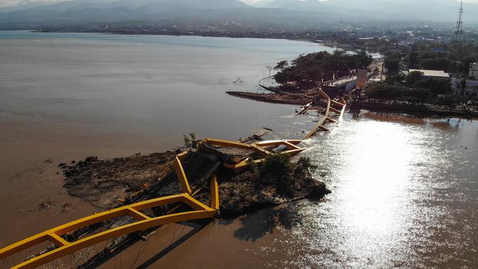 Pandangan udara memperlihatkan sebuah jembatan runtuh usai dilanda gempa dan tsunami Palu, Sulawesi Tengah, Senin (1/10). Jumlah korban tewas akibat gempa dan tsunami Palu dan Donggala menjadi 832. (JEWEL SAMAD/AFP)