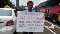 Seorang Supir Taksi membawa spanduk saat demo di depan Gedung DPR/MPR, Jakarta, Selasa (22/3/2016). Selain melakukan demo, supir taksi tersebut melakukan sweeping ke supir taksi yang beroperasi di dalam tol dan membakar ban. (Liputan6.com/Johan Tallo)