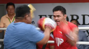 Petinju Filipina, Manny Pacquiao bertanding dengan teman masa kecilnya dan asisten pelatih lama Buboy Fernandez selama sesi pelatihan di gym di Manila, (17/5). Pacquiao akan bertanding melawan petinju Argentina Lucas Matthysse. (AFP Photo/Ted Aljibe)