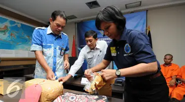 Deputi Pemberantasan BNN, Arman Depari (kiri) memeriksa barang bukti sabu saat rilis di Jakarta, Selasa (24/5/2016). BNN kembali mengungkap dua kasus penyelundupan narkoba jenis sabudengan tujuh orang tersangka. (Liputan6.com/Helmi Fithriansyah)