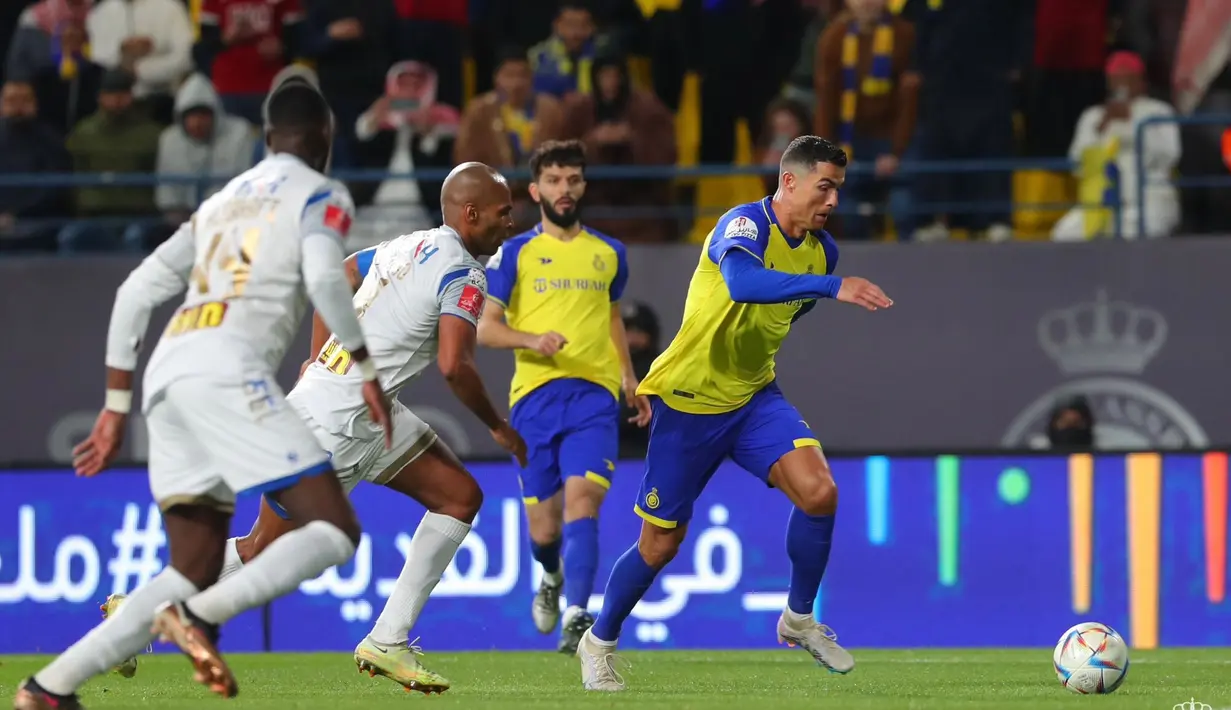 Pemain Al Nassr, Cristiano Ronaldo (kanan) mengontrol bola dibayangi pemain Al Taawoun pada pertandingan pekan ke-17 Liga Arab Saudi 2022/2023 yang berlangsung di Mrsool Park, Jumat (17/2/2023) WIB. Ronaldo memberikan umpan cantik dari tengah lapangan. (Twitter/Al Nassr FC)