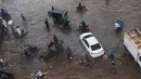 Sejumlah warga melintasi banjir saat beraktivitas setelah hujan deras di Lahore, Pakistan (16/7/2019). Di Kashmir yang dikelola Pakistan, para pejabat pemerintah mengatakan sedikitnya 23 orang tewas setelah hujan lebat memicu banjir bandang. (AFP Photo/Arif Ali)