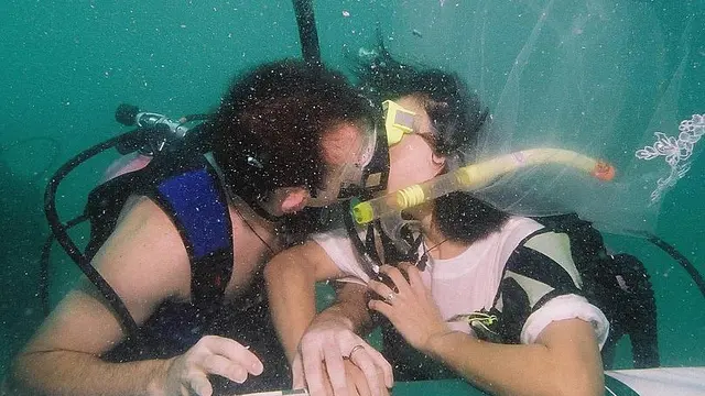 Sepasang kekasih berciuman saat merayakan Hari Valentine dengan berpartisipasi dalam pernikahan bawah laut di pulau Kradan di Trang, Thailand. (AFP)