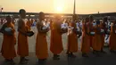 Sejumlah biksu muda berbaris untuk menerima sedekah usai melakukan ritual Makha Bucha Day di kuil Wat Dhammakaya, Bangkok, Thailand (11/2). (AFP/Lillian Suwanrumpha)