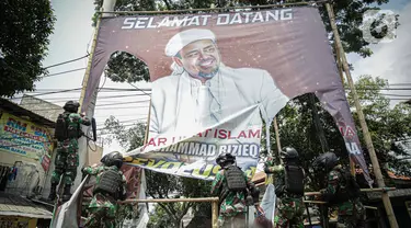 Anggota TNI mencopot paksa baliho Rizieq Shihab yang terpasang di sekitar kawasan Petamburan, Jakarta, Jumat (20/11/2020). Pencopotan dilakukan karena menyalahi aturan yang telah ditetapkan. (Liputan6.com/Faizal Fanani)
