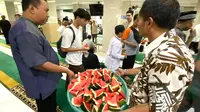 Jemaah masjid Al Jihad makan semangka usai salat Jumat. (Liputan6.com/Aslam Mahfuz)