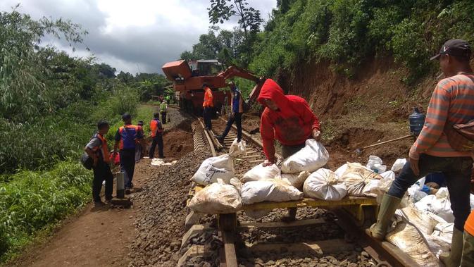 Petugas PT KAI tengah memperbaiki rel kereta api Bogor-Sukabumi yang menggantung akibat tanah landasannya ambrol pada Rabu (3/1/2019) sore.