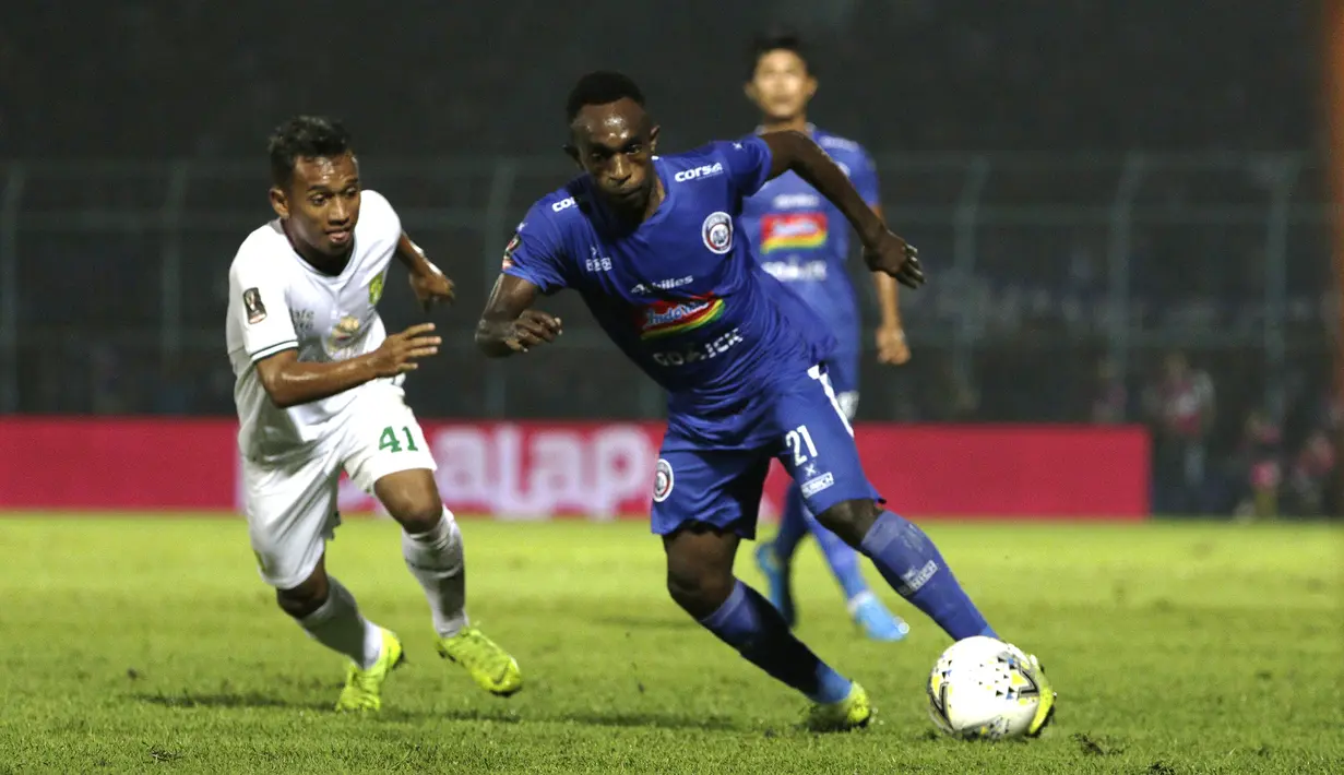 Gelandang Arema FC, Ricky Kayame, berusaha melewati penyerang Persebaya Surabaya, Irfan Jaya, pada laga Piala Presiden 2019 di Stadion Kanjuruhan, Jumat (13/4). Arema FC menang 2-0 atas Persebaya. (Bola.com/Yoppy Renato)