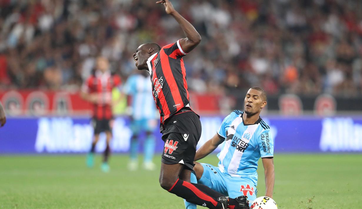 Pemain Nice, Mario Balotelli (kiri) dihadang pemain Olympique de Marseille, illiam Jacques Vainqueur pada lanjutan Ligue 1 Prancis di "Allianz Riviera" stadium, (12/9/2016) dini hari WIB. Nice menang 3-2. (AFP/ Valery Hache)