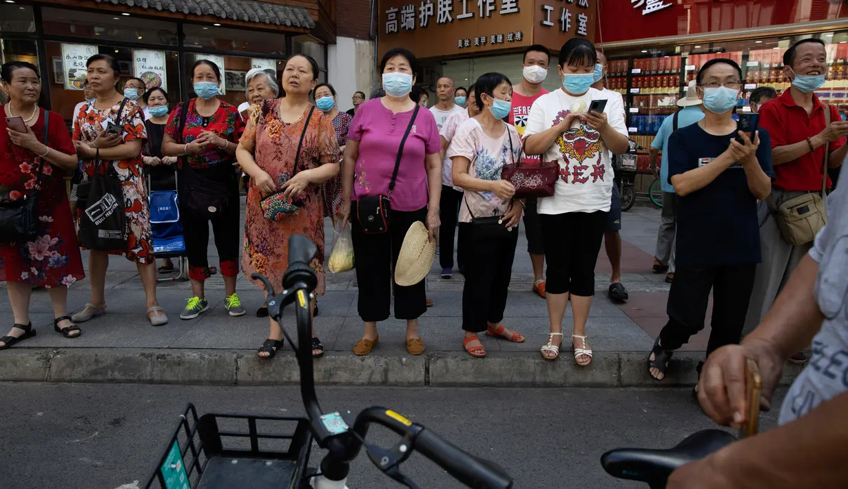 Penutupan Konsulat AS Jadi Tontonan: Orang-orang berkumpul saat pihak berwenang China bersiap untuk memasuki Konsulat AS di Chengdu, Senin (27/7/2020). Bendera Amerika Serikat di Konsulat AS Chengdu diturunkan menandai ditutupnya kantor perwakilan Negeri Paman Sam di kota itu. (AP Photo/Ng Han Guan)