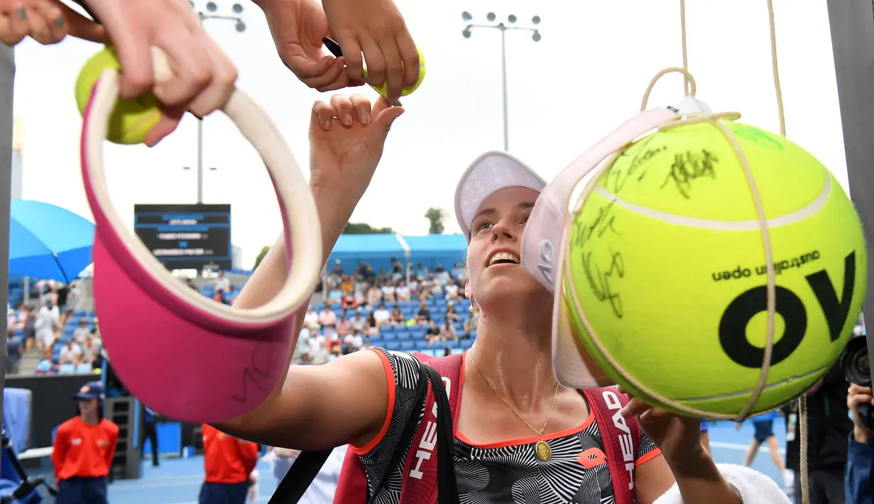 Petenis Belgia, Elise Mertens menandatangi bola yang disodorkan penggemarnya setelah mengalahkan Margarita Gasparyan dari Rusia pada pertandingan tunggal putri turnamen Australia Terbuka di Melbourne, Kamis (17/1). (Photo by WILLIAM WEST / AFP)