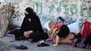 Para pengungsi terpaksa bermalam di pinggir jalan atau di tempat-tempat terbuka untuk menghindari serangan Israel. (JOSEPH EID/AFP)