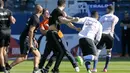 Seorang suporter masuk ke lapangan dan menyerang pemain Lyon yang sedang melakukan pemanasan di Armand Cesari stadium, Bastia, (16/4/2017). Laga ini akhirnya dihentikan LFP. (AFP/Pascal Pochard-Casabianca)