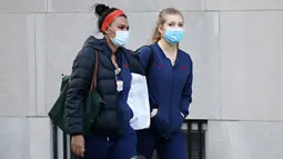 Dua pekerja medis tiba untuk giliran kerja di NewYork-Presbyterian Hospital / Weill Cornell Medical Center selama pandemi COVID-19 di New York City (21/4/2020). (Cindy Ord/Getty Images/AFP)