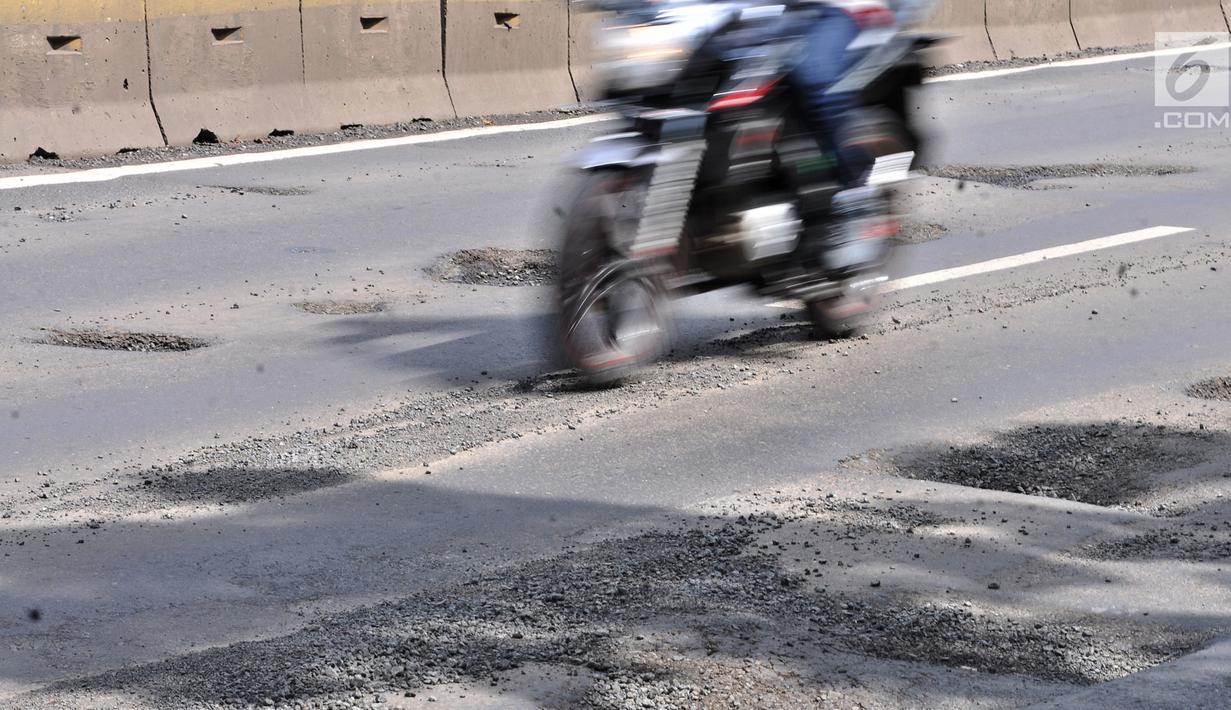 Pengendara motor melintasi jalan berlubang di Gunung Sahari, Jakarta, Selasa (29/1). Sedikitnya terdapat 8 titik jalan rusak dan berlubang di sepanjang Jalan Gunung Sahari berdiameter hingga 10 cm dengan kedalaman 10 cm. (Merdeka.com/Iqbal S. Nugroho)