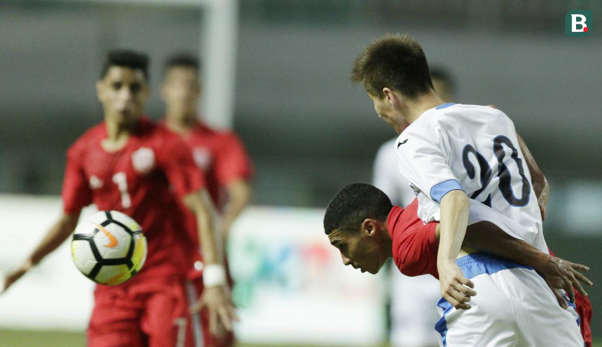 Pemain Uzbekistan, Muydinov Umidjon, duel udara dengan pemain Bahrain, Ahmed Sanad, pada laga PSSI Anniversary Cup 2018 di Stadion Pakansari, Senin (30/4/2018). Uzbekistan bermain imbang 3-3 dengan Bahrain. (Bola.com/M Iqbal Ichsan)