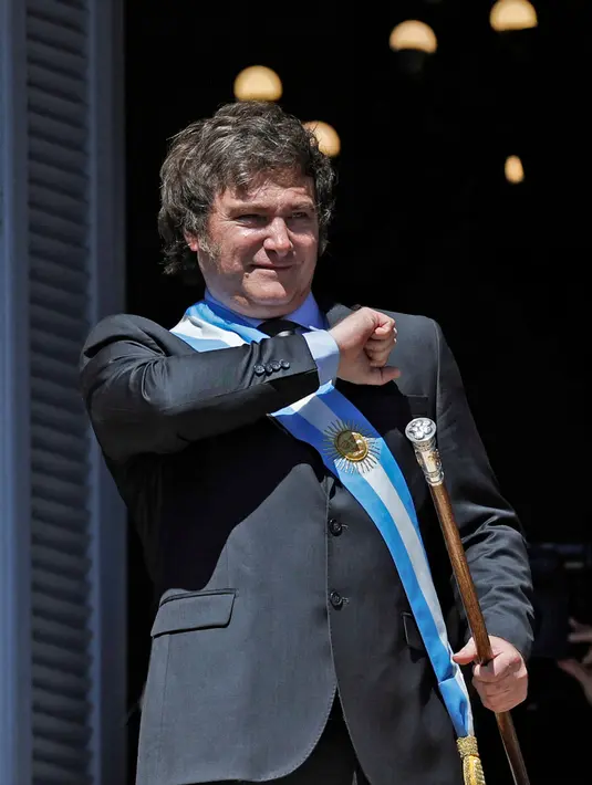 Presiden baru Argentina Javier Milei memberi isyarat kepada kerumunan orang dari balkon istana pemerintah Casa Rosada pada hari pelantikannya di Buenos Aires pada 10 Desember 2023. (Emiliano LASALVIA/AFP)