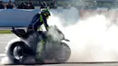 Pebalap Movistar Yamaha, Valentino Rossi, melakukan burn out setelah finis keempat dalam balapan MotoGP Valencia di Sirkuit Ricardo Tormo, Minggu (13/11/2016). (AFP/Jose Jordan)