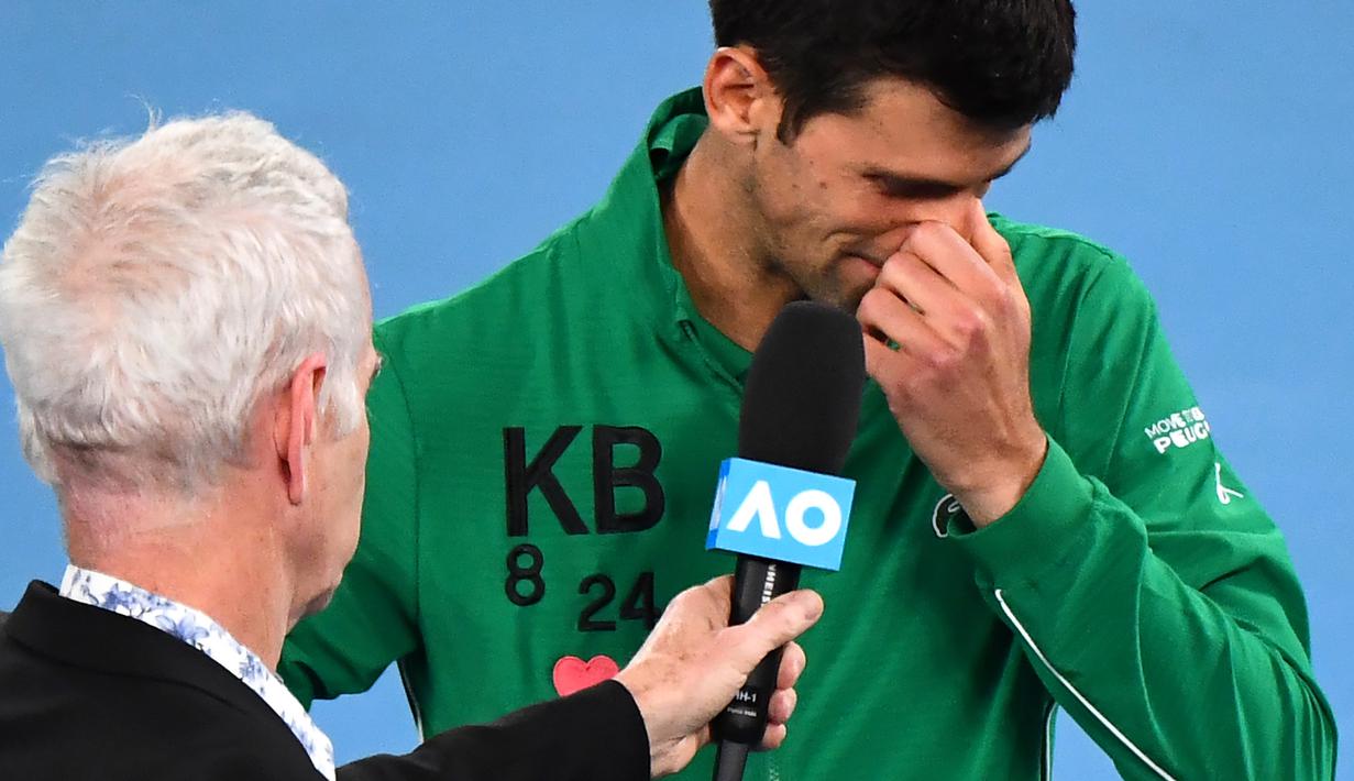 Petenis Serbia, Novak Djokovic, menangis saat diwawancara tentang Kobe Bryant seusai laga Australia Open 2020 di Melbourne, Selasa (28/1). Beri penghormatan dirinya memakai jaket inisial Kobe Bryant. (AFP/William West)