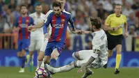 Lionel Messi mendapat adangan dari bek Real Madrid, Sergio Ramos dpada duel El Clasico di Santiago Bernabeu stadium, Madrid, Spanyol, Minggu, (23/4/2017). Barcelona menang 3-2.  (AP/Daniel Ochoa de Olza)