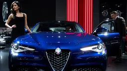 Model berpose di samping Alfa Romeo Giulia saat pameran North American International Auto Show 2017 di Detroit, Michigan, AS (9/1). Pameran ini diadakan dari tanggal 8 sampai 22 Januari 2017. (AFP Photo/Jim Watson)