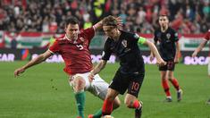 Aksi Luka Modrid melewati pemain Hungaria, Adam Szalai pada laga kedua babak kualifikasi Piala Eropa 2020 Grup E yang berlangsung di Stadion Groupama Arena, Budapest, Senin (25/3). Kroasia kalah 1-2 kontra Hungaria. (AFP/Attila Kisbenedek)