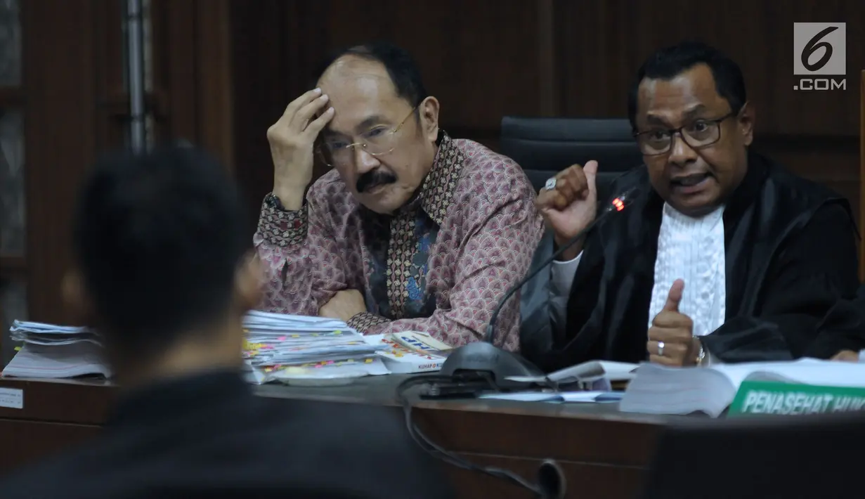 Terdakwa kasus merintangi penyidikan dugaan korupsi e-KTP, Fredrich Yunadi (kiri) menymak keterangan stafnya pada sidang lanjutan di Pengadilan Tipikor, Jakarta, Kamis (12/4). Sidang mendengar keterangan saksi. (Liputan6.com/Helmi Fithriansyah)