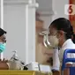 Petugas mendata warga yang mengikuti vaksinasi COVID-19 di Vihara Avalokhitesvara, Mangga Besar, Jakarta, Minggu (29/8/2021). Hal ini dilakukan untuk mencapai herd immunity atau kekebalan komunal di wilayah tersebut. (Liputan6.com/Herman Zakharia)