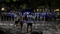 Polisi anti huru hara berjaga-jaga setelah bentrok dengan suporter Argentina setelah perayaan timnas Argentina meraih juara Piala Dunia Qatar 2022 di lingkungan Obelisk di Buenos Aires (20/12/2022). Kerusuhan pecah pukul 20.00 malam. Kericuhan bermula saat petugas hendak membubarkan penggemar yang membobol struktur dan memanjat monumen Obelisk. (AFP/Luis Robayo)