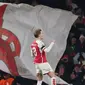 Martin Odegaard merayakan gol kelima Arsenal dalam pertandingan Grup B Liga Champions melawan Lens di Emirates Stadium, London, Kamis (30/11/2023) dini hari WIB. Arsenal menang 6-0. (Adrian DENNIS / AFP)