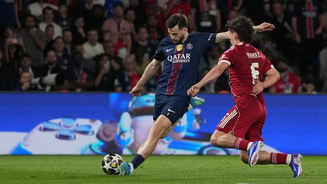 Pemain Liverpool Milos Kerkez (kanan) mencoba memblok tembakan pemain PSG Khvicha Kvaratskhelia