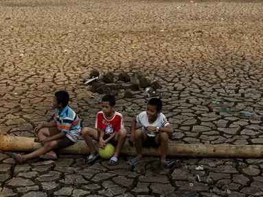 Anak-anak bermain di atas tanah retak Situ Cilodong, Kalibaru, Depok, Rabu (30/9/2015). Musim kemarau panjang menyebabkan situ Cilodong di Kelurahan Kalibaru, Cilodong mengalami kekeringan. (Liputan6.com/Yoppy Renato)