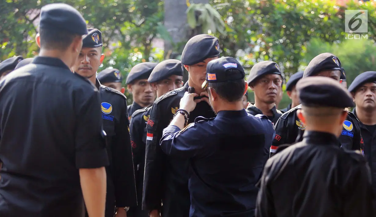 Ketua DPP Partai NasDem Bidang Otda Syahrul Yasin Limpo mengecek pasukan saat upacara peringatan Hari Kesaktian Pancasila di DPP Partai NasDem, Jakarta, Senin (1/10). Upacara ini bertujuan mengenang jasa pahlawan revolusi. (Liputan6.com/Herman Zakharia)