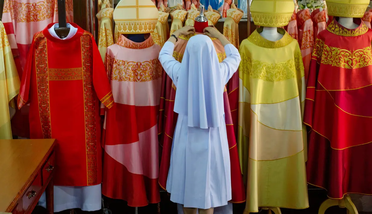 Suster Sukanya Sukchai merapikan jubah yang akan digunakan Paus Fransiskus saat mengunjungi Thailand di sekolah persiapan Katolik, Bangkok, Jumat (8/11/2019). (AP Photo/Gemunu Amarasinghe)