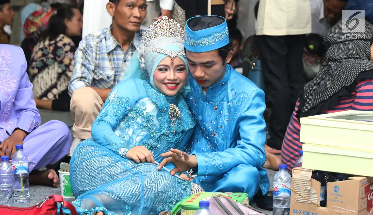 Pasangan nikah massal meluapkan kebahagiaan usai ijab kabul di jalan MH Thamrin, Jakarta, Senin (31/12). 557 pasangan mengikuti nikah massal dan isbat nikah pada malam pergantian tahun 2018-2019. (Liputan6.com/Helmi Fithriansyah)