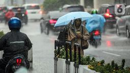 Pejalan kaki menggunakan payung saat hujan deras di kawasan Thamrin, Jakarta, Rabu (23/11/2022). Sejak Oktober, DKI Jakarta mulai memasuki musim penghujan yang sudah masuk ke dalam tahap ekstrem. (Liputan6.com/Faizal Fanani)
