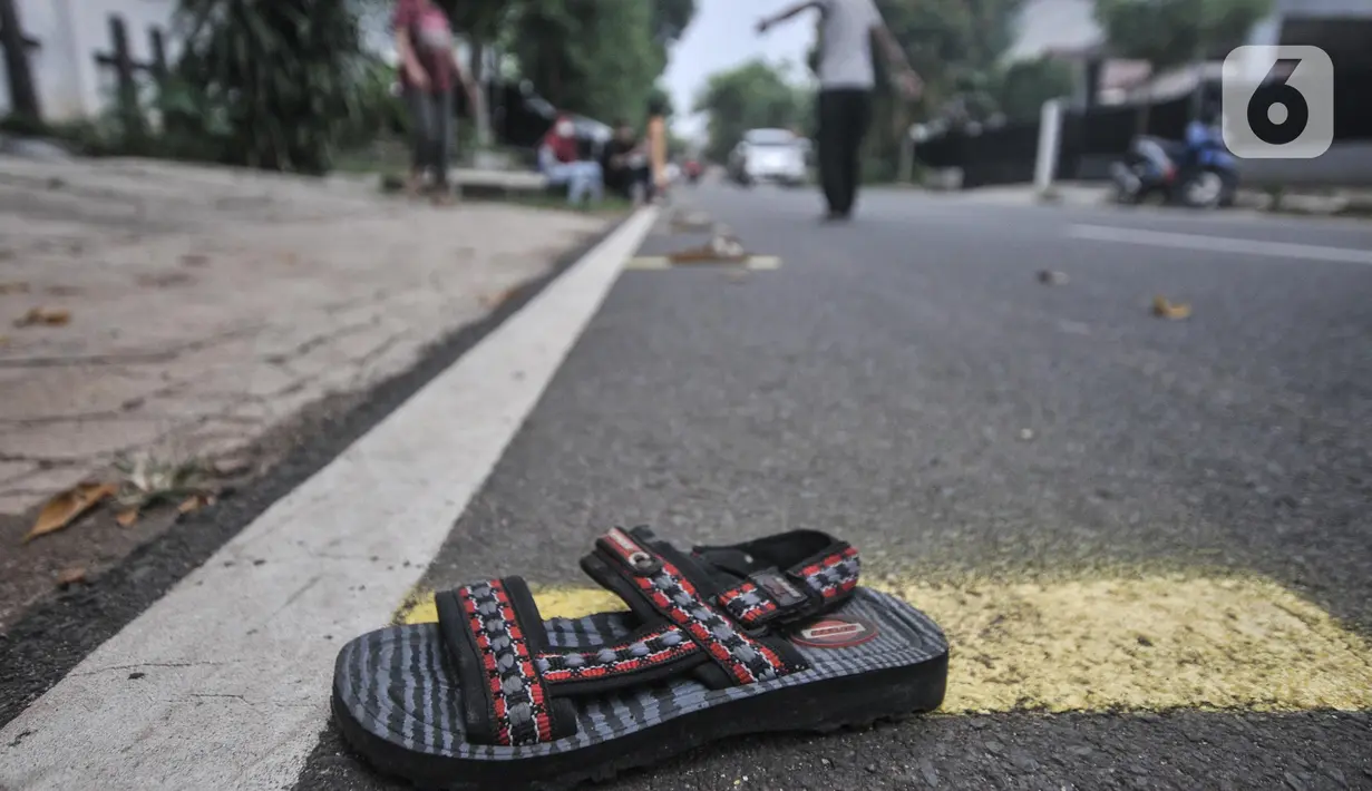 Warga menggunakan sandal untuk menandai antrean takjil gratis di Cempaka Putih, Jakarta, Selasa (19/4/2022). Pembagian takjil gratis yang telah berlangsung sejak pandemi Covid-19 ini disambut antusias warga, baik anak-anak hingga orang dewasa. (merdeka.com/Iqbal S. Nugroho)