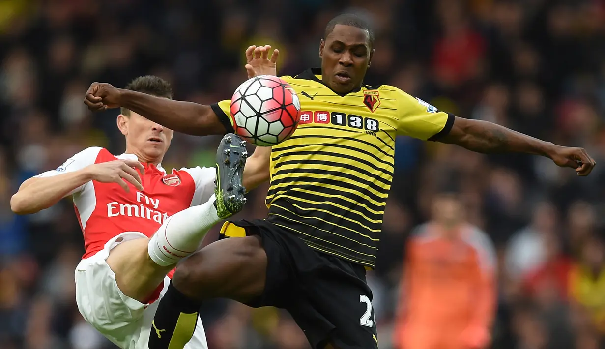 Striker Watford, Odion Ighalo (depan) berebut bola dengan bek Arsenal, Laurent Koscielny pada laga Liga Inggris 2015/2016 di Vicarage Road Stadium, Watford (17/10/2015). Odion Ighalo hanya membela 2 klub EPL di Liga Inggris selama 3,5 musim, yaitu Watford dan Manchester United. Torehan 16 gol menjadi catatan terbaiknya pada musim 2015/2016 bersama Watford. (AFP/Paul Ellis)