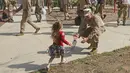 Seorang Angkatan Laut AS menyambut anaknya saat tiba di Camp Pendleton di Oceanside, California, AS, Kamis (11/5). (AFP/ Sandy Huffaker)